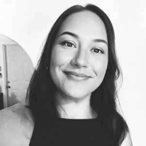 black and white image of woman, Lola Rathke Shearer, graphic designer, slightly smiling, with long dark hair parted down the center
